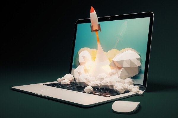 Laptop with rocket blasting out of the screen, representing accomplishing a digital advertising goal