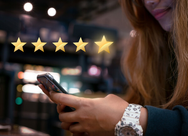 Woman using mobile device leaving 5 star review