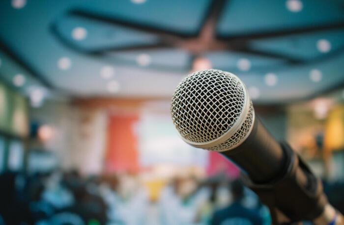 Microphone in foreground with twinkling lights and bright colors in background