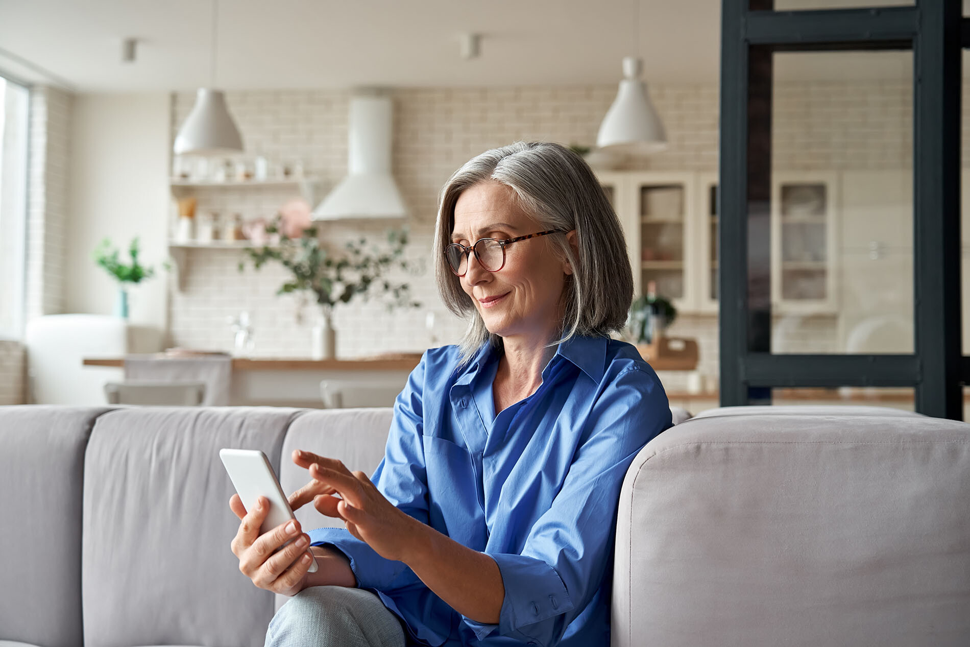 Woman with chin-length gray hair watching videos on a smartphone