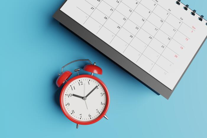 calendar and alarm clock on a neutral blue background